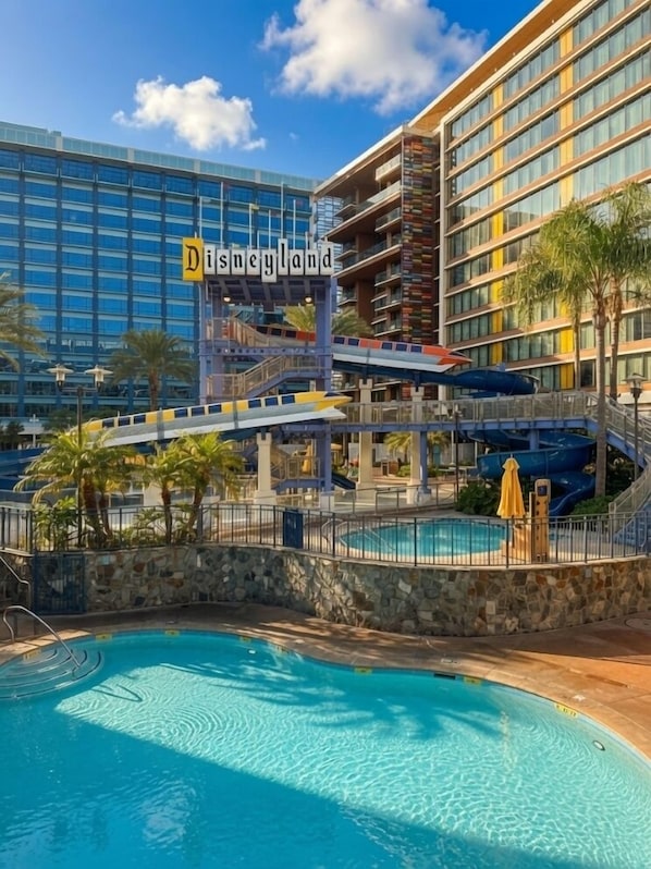 A hotel with a pool, a water slide, and a sign reading 'Disneyland.'