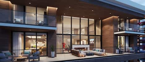 A modern multi-story building with a spacious outdoor seating area, large windows, and a mix of indoor and outdoor living spaces.