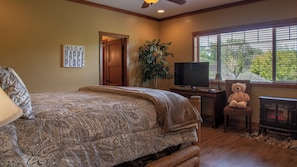 A bedroom with a bed, a television, a teddy bear, a fireplace, and a window with blinds. - The J's Nest Deluxe by Avantstay Sleeps 18 Hot Tub + Game Room Paso Robles (Bradley)