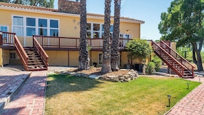 A two-story building with a brick pathway, wooden stairs, and a grassy area. - Union Road Schoolhouse by Avantstay Sleeps 10 + Pizza Oven + Spa + Firepit Historic 1923 Estate (Paso Robles)