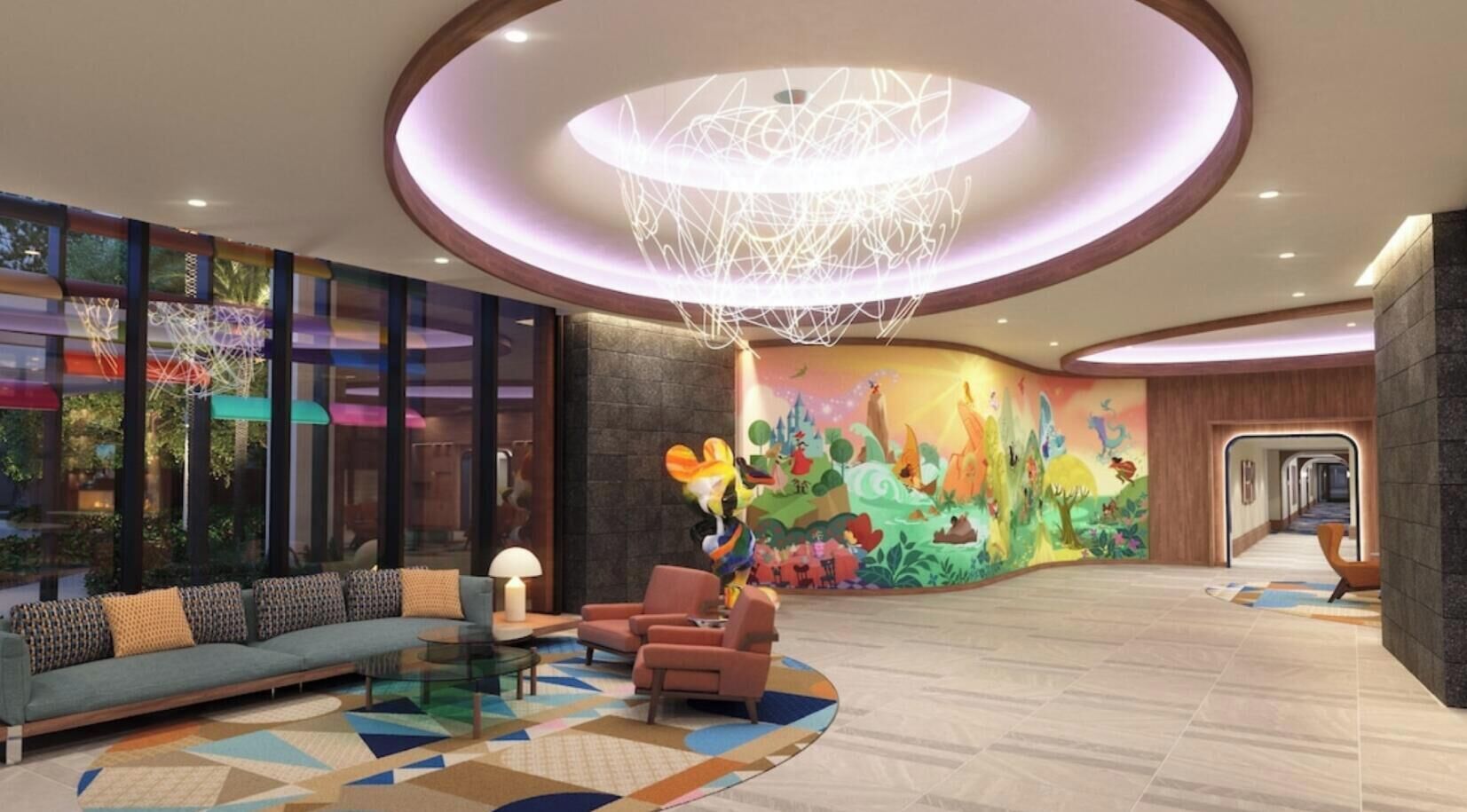 Eine Lobby im modernen Stil, mit einer Sitzecke mit Sofas und Sesseln, einem farbenfrohen Wandgemälde und einer besonderen Deckenleuchte.