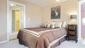 A bedroom with a bed, a painting on the wall, a lamp, and a storage unit. - Vacations on Vine by Avantstay BBQ Yard + Patio Paso Robles Wine Country (Paso Robles)