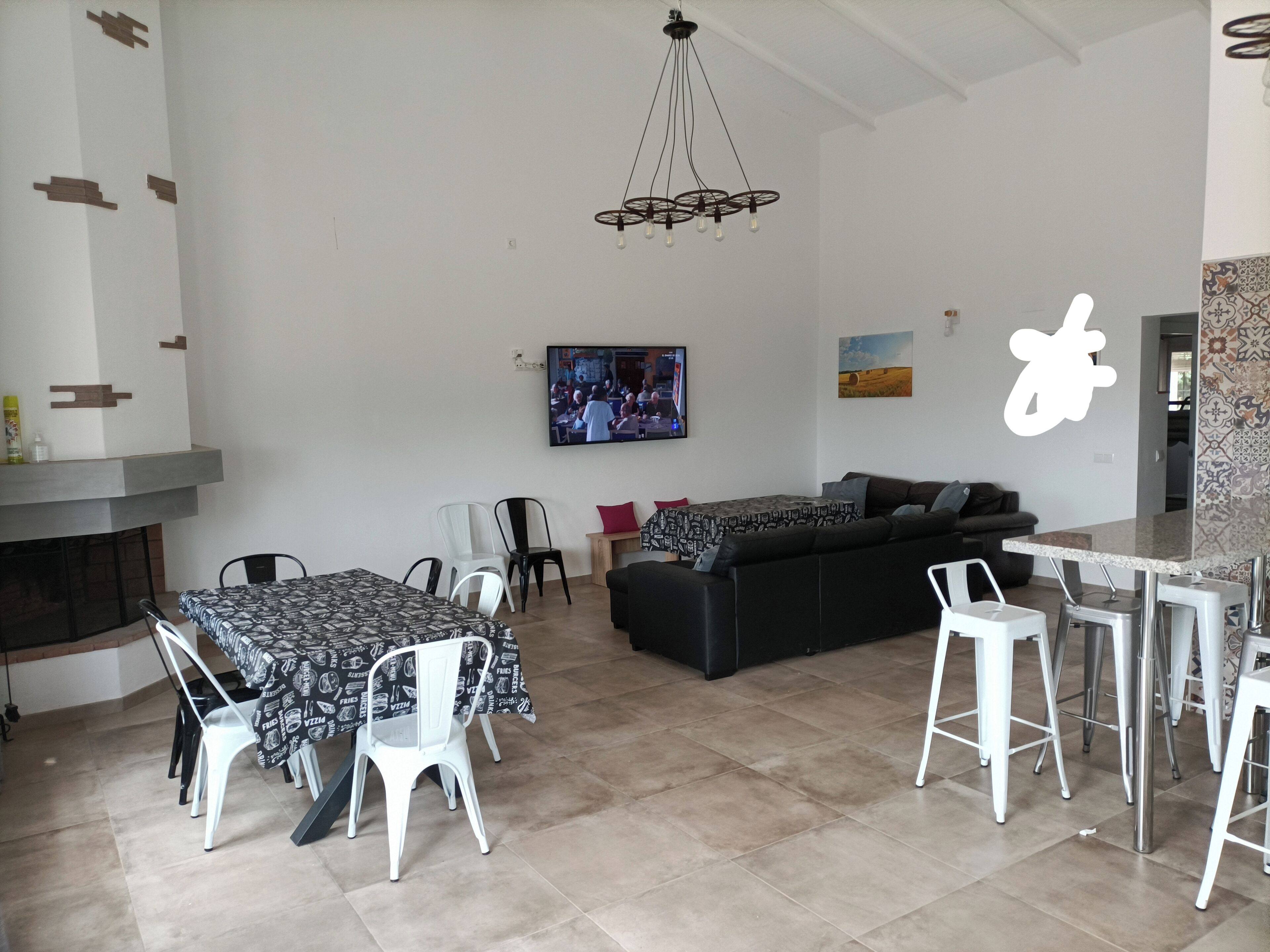 Un salon moderne comprenant un canapé, une table à manger, des chaises, un téléviseur et une cheminée.