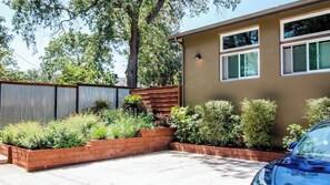 A residential property with a fenced garden area, a car parked in the driveway, and a building with a brown exterior. - Twice is Nice by Avantstay Gourmet Kitchen + Heated Baths Downtown Paso Robles Wine Country (Paso Robles)
