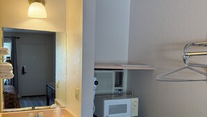 A bathroom with a sink, mirror, towel rack, and a black refrigerator.