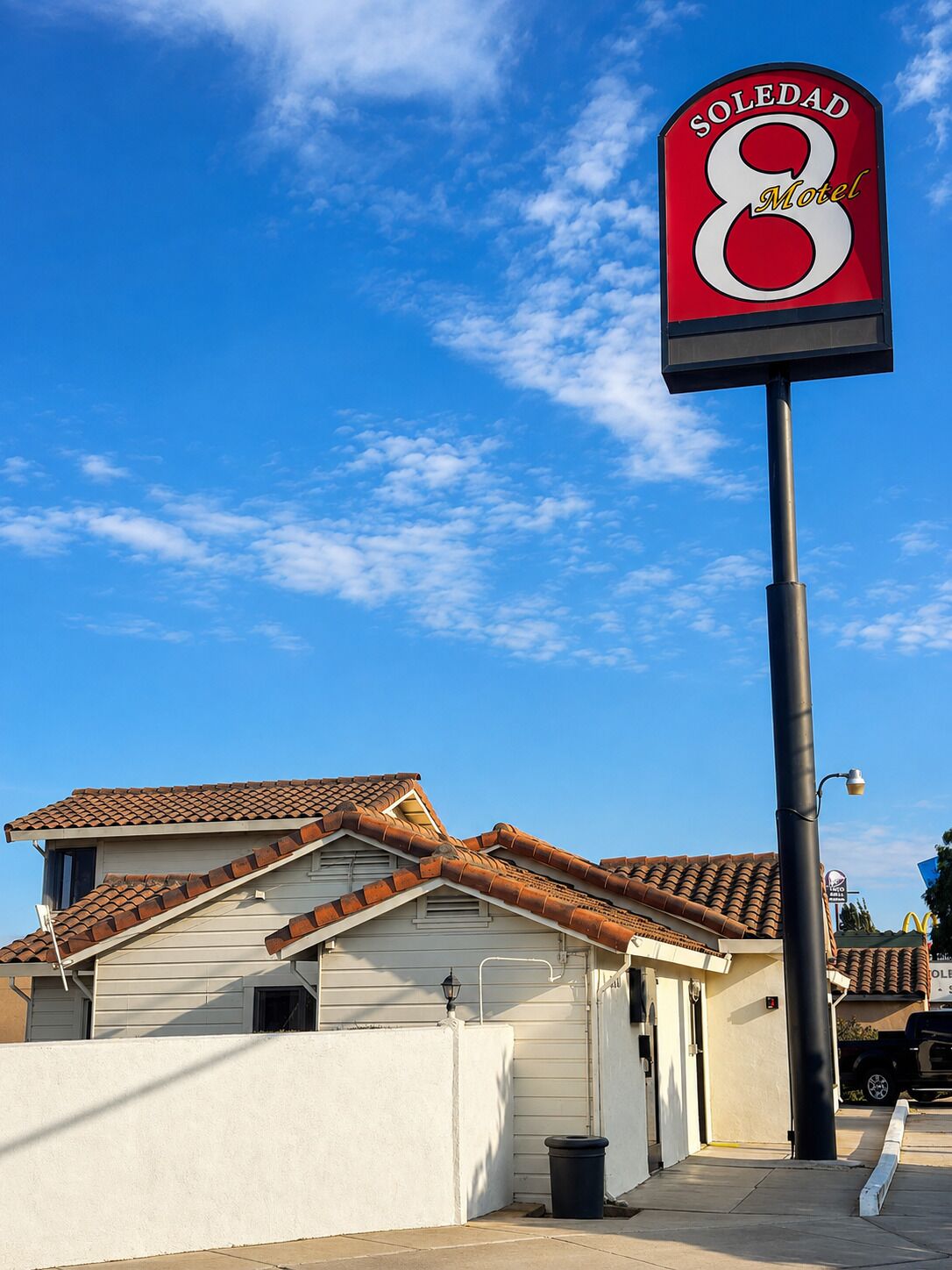 A motel sign with the name 'SOLEDAD 8 Motel' against a clear blue sky.