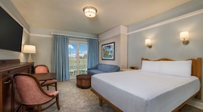 A hotel room with a bed, a desk, a chair, a television, and a window with curtains. - Orlando | Compact Disney Retreat | Pool + Waterpark (Lake Buena Vista)