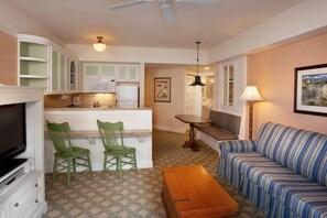 A compact living space with a kitchenette, a dining area, a sofa, and a television. - Orlando | Romantic Park Retreat | Pool + Waterpark (Lake Buena Vista)