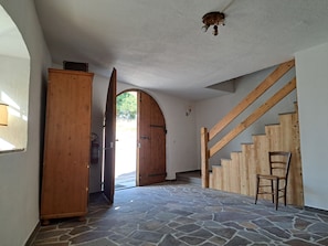 A room with a stone floor, wooden staircase, and a door leading outside. - Fabulous, welcoming and rustic
mountain house, perfect for your getaway in Italy (Salter)