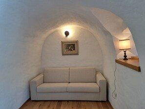 A cozy room with a sofa, a lamp, and a painting on the wall. - Fabulous, welcoming and rustic
mountain house, perfect for your getaway in Italy (Salter)