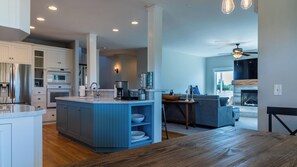 A modern kitchen with a central island, built-in appliances, and a dining area with a wooden table. - Graceful Oaks by Avantstay Pool + Oak Trails + Lawn Games Near Paso Robles (Paso Robles)