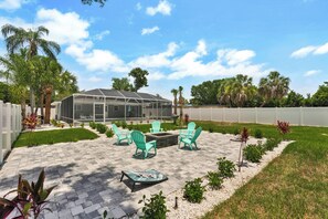 A patio area with outdoor seating and a covered structure. - Pool home 10 minutes to beaches.  Sleeps 6.  Outdoor Fireplace with grill grate. (Sarasota)