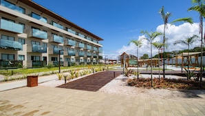 A modern hotel with multiple balconies, a central courtyard, and a pool area. - Beachfront Condos at Ipioca Beach Life Maceio by MME (Maceió)