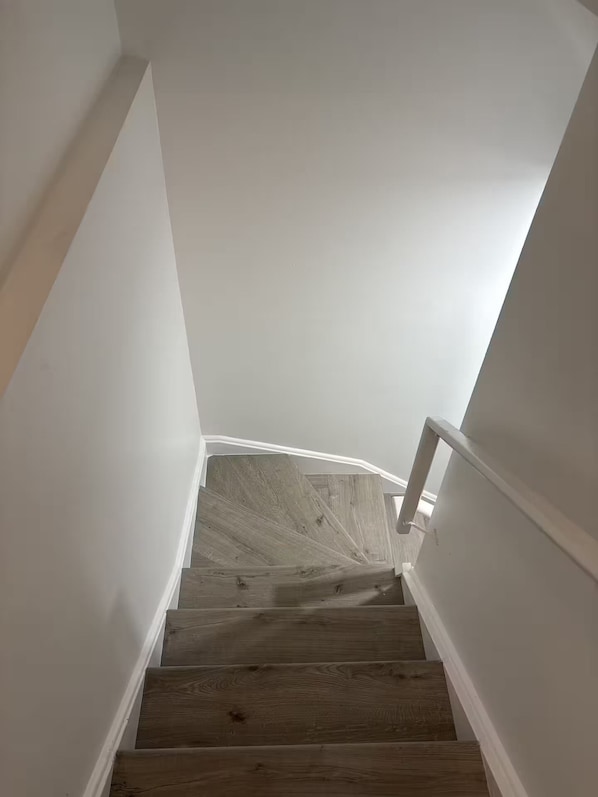 A staircase with wooden steps and white walls.