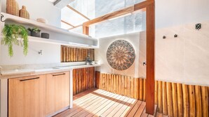 A modern kitchen with wooden cabinets, a white countertop, and a mosaic wall. - Beautiful Apartment Near the Beach Sov0005 (Mata de São João)
