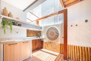 Una cocina moderna con armarios de madera, encimera blanca y pared de mosaicos.