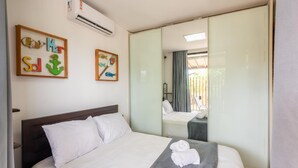 Una habitació d'hotel amb un llit, un mirall i obres d'art a la paret.