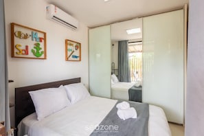 Ein Hotelzimmer mit einem Bett, einem Spiegel und Kunstwerken an der Wand.