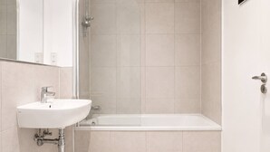 Ein modernes Badezimmer mit Waschbecken, Toilette und Badewanne.