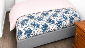 Ein Schlafzimmer mit einem Bett, einem Nachttisch aus Holz und einem Wandbild.