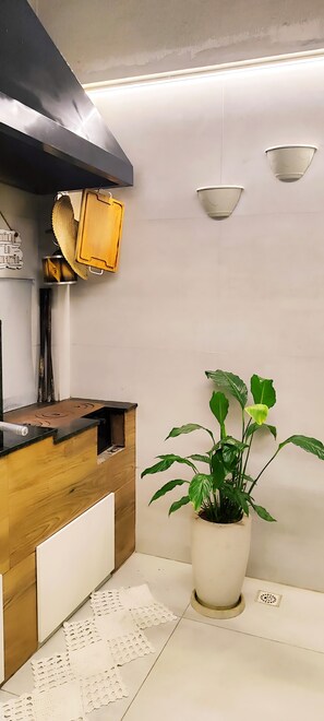 A kitchen with a wooden countertop, a potted plant, and a hanging pot rack. - JKLL INN 1980 HOME FULL 15 min from CWB Airport / 5 min from the Botanical Garden  (Curitiba)