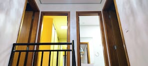 A hallway with wooden doors leading to a bathroom.