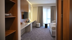 A hotel room with a bed, a desk, a chair, a television, and a window with curtains. - Janset Boutique Hotel (Diyarbakır)