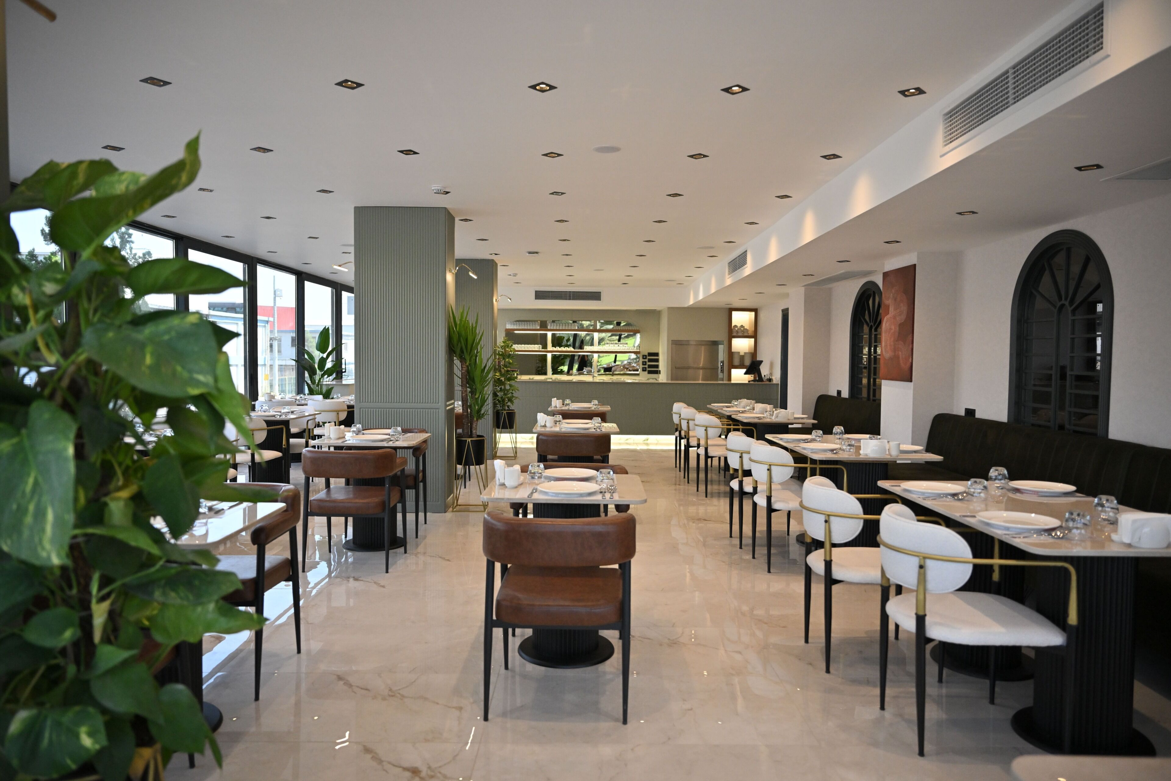 Un intérieur de restaurant moderne avec un bar central, des tables et des chaises.