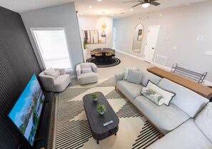 A modern living room with a sofa, armchairs, a coffee table, and a TV. - Brilliant 3-bedroom house with AC in charming Kissimmee (Kissimmee)