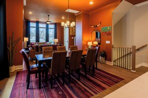 A dining area with a wooden table, leather chairs, and a patterned rug. - The Wild West - Nashville: Rooftop Deck (Nashville)
