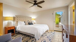 A bedroom with a bed, a ceiling fan, a nightstand, a lamp, a chair, and a view of the outdoors through a door. - Above It All by Avantstay Pool + Hot Tub + Fire Pit Hilltop Near Paso (Paso Robles)