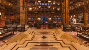 A spacious library with high wooden ceilings, multiple levels, and a central carpeted area with geometric patterns. - Orlando | Family Lodge Retreat | Pool + Resort | 2BR (Lake Buena Vista)