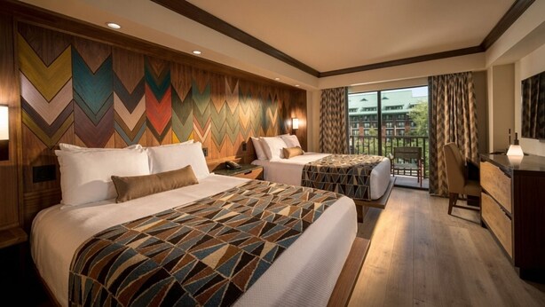A hotel room with two beds, a desk, a chair, and a balcony with a view. - Orlando | Family Lodge Retreat | Pool + Resort | 2BR (Lake Buena Vista)