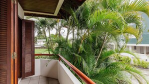 A balcony with a wooden railing, surrounded by lush green palm trees. - Apt 270m From the Beach in Floripa-sc Stcy202 (Florianópolis)
