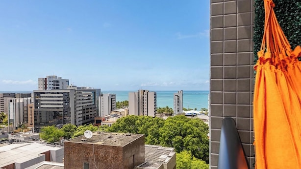 A cityscape with high-rise buildings, a clear sky, and a view of the sea. - Apt in Condo w/ Pool & Sea View Sli1013 (Maceió)