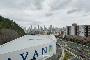 Un edificio con señalización 'AVAN', rodeado de un paisaje urbano con rascacielos y una calle con vehículos.
