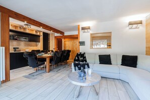 Ein modernes Interieur mit Essbereich, einer Sitzecke und Blick ins Freie.