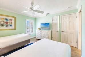 A bedroom with a bed, a dresser, a ceiling fan, and a framed picture of seashells. - Beachfront Home w/ Screened Lanai & Pool Access (Captiva)