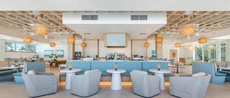 Un espacio de bar moderno con asientos, una barra y lámparas colgantes.