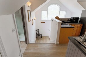 A kitchen with wooden cabinets, a black countertop, and a window above the sink.