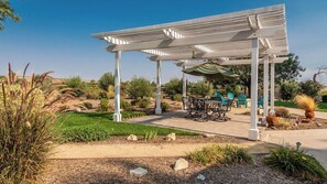 A covered outdoor seating area with tables and chairs, surrounded by landscaped gardens and a clear sky. - Estrella Vineyard by Avantstay Vineyard Setting + Fire Pit Backyard Northern Paso Wine Country (San Miguel)