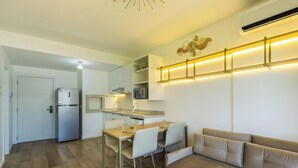 Una cocina moderna con comedor, electrodomésticos integrados y una lámpara de pared.