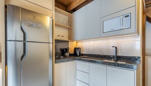 A modern kitchen with a stainless steel refrigerator, a coffee maker, and a built-in microwave. - Chalet w/ Balcony in Condo w/ Barbecue Vil0003 (Penha)