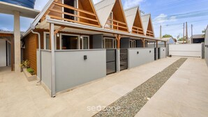 A modern building with a wooden facade, multiple windows, and a gated entrance.