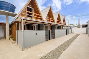 A modern building with a wooden facade, multiple windows, and a gated entrance. - Chalet in Condo w/ Barbecue and Bonfire Vil0004 (Penha)