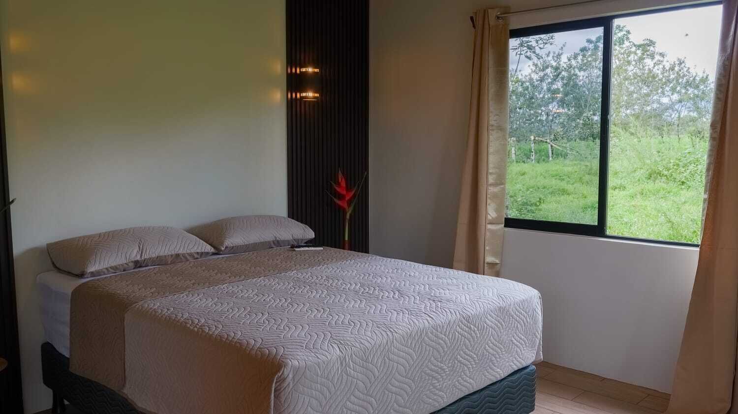 Una camera da letto con un letto, una finestra e vista sul verde.