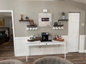 A coffee bar setup with a coffee machine, mugs, and coffee-related items on a white table. - Fireline's Ocala Retreat Near WEC, Springs Hot Tub! (Ocala City)