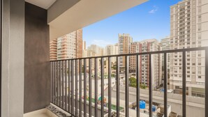 A balcony with a view of high-rise buildings and a street below. - Complete Studio in Perdizes Cep00428 (São Paulo)