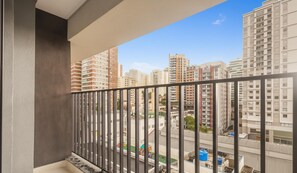 A balcony with a view of high-rise buildings and a street below. - Complete Studio in Perdizes Cep00428 (São Paulo)