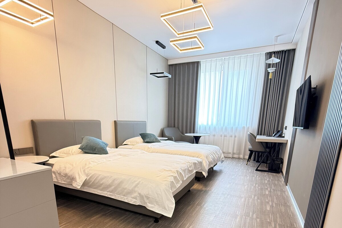 Una habitación de hotel con una cama grande, un escritorio, una silla y un televisor.
